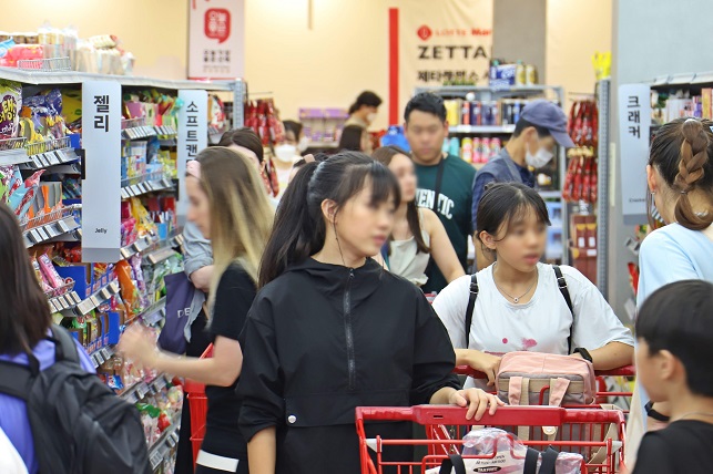 This photo provided by Lotte Shopping Co. on Sept. 6, 2023, shows foreigners shopping at Lotte Mart's Seoul Station branch in central Seoul.