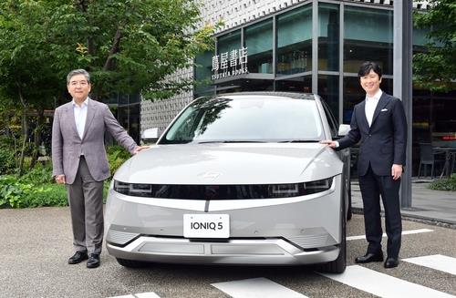 Hyundai Motor President and CEO Chang Jae-hoon (L) and CCC President and Chief Operating Officer Yasunori Takahashi pose for a photo with the carmaker's all-electric Ioniq 5 model outside the large Daikanyama T-Site Tsutaya bookstore in Tokyo on June 22, 2023, in this file photo provided by the South Korean company. (Image courtesy of Yonhap)