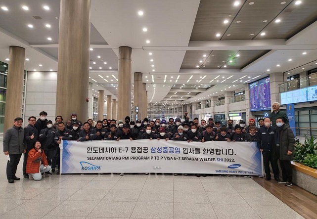 This file photo, provided by Samsung Heavy Industries Co., shows a group of Indonesians posing for a photo upon arrival at Incheon International Airport, west of Seoul, on Jan. 2, 2023, to work for the company. 