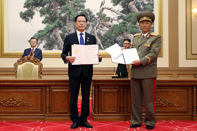 This file photo, taken Sept. 19, 2018, shows then Defense Minister Song Young-moo (2nd from L) and his North Korean counterpart, No Kwang-chol, posing for a photo after signing the Comprehensive Military Agreement at the Baekhwawon state guesthouse in Pyongyang. Then President Moon Jae-in (L) and North Korean leader Kim Jong-un (2nd from R) are seen in the back. (Image courtesy of Yonhap News)