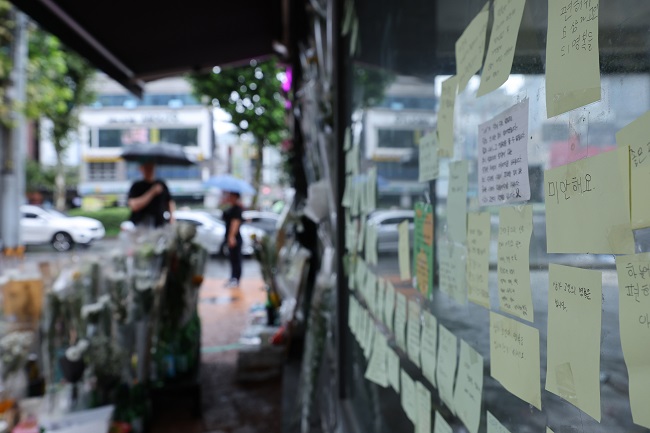 Flowers and messages of condolences are laid out at a makeshift memorial in an alley near Sillim Station in this file photo taken July 23, 2023, where a man was killed and three others wounded in a stabbing rampage on July 21. (Yonhap)