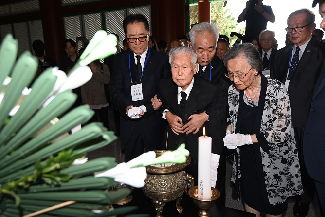 Rhee In-soo (C) and his wife pay tribute in front of a memorial altar for the victims of the April 19 Revolution at their cemetery in northern Seoul on Sept. 1, 2023. (Pool photo) (Yonhap)